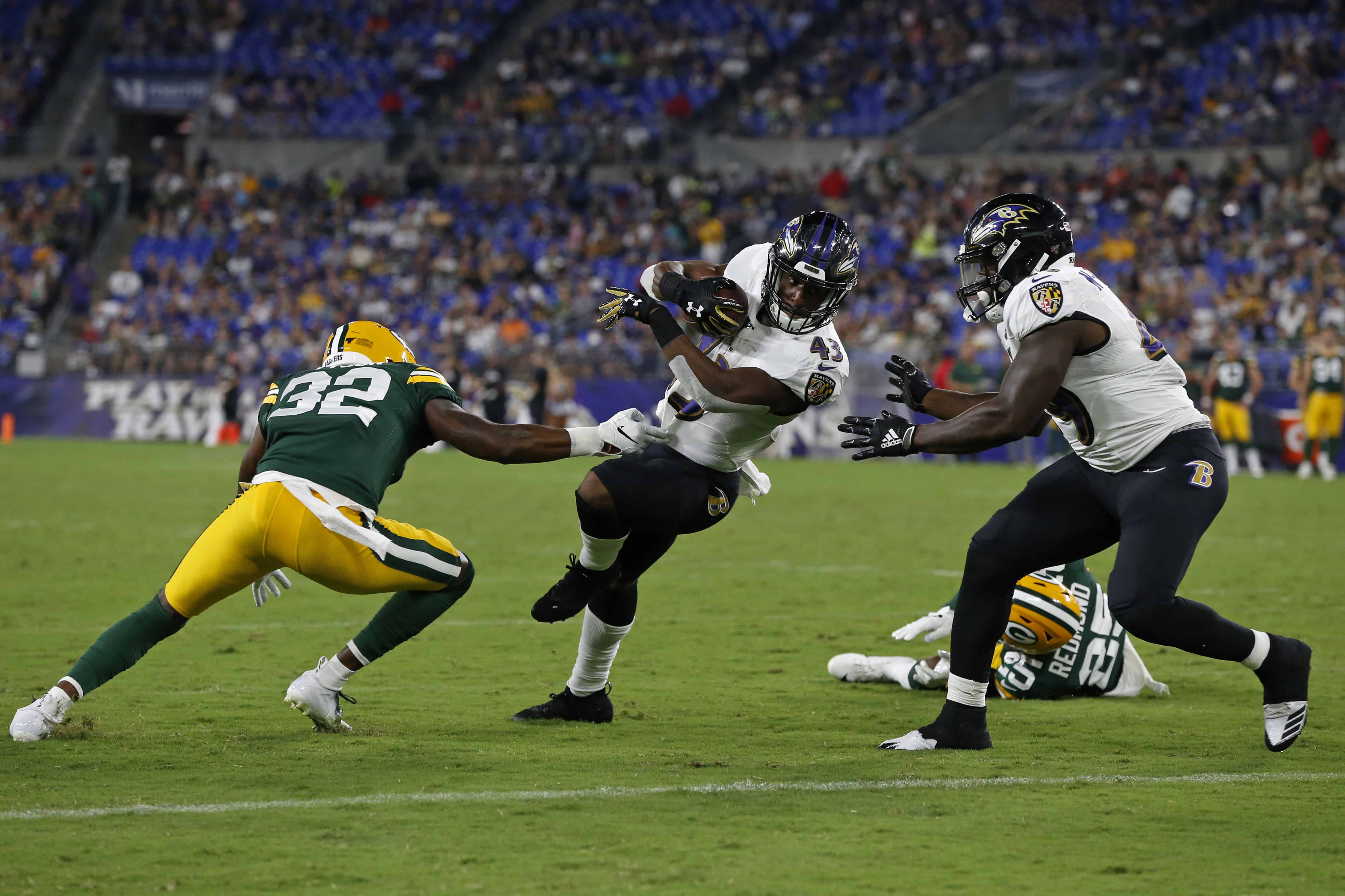 Ravens running back Justice Hill breaks tackle against Packers