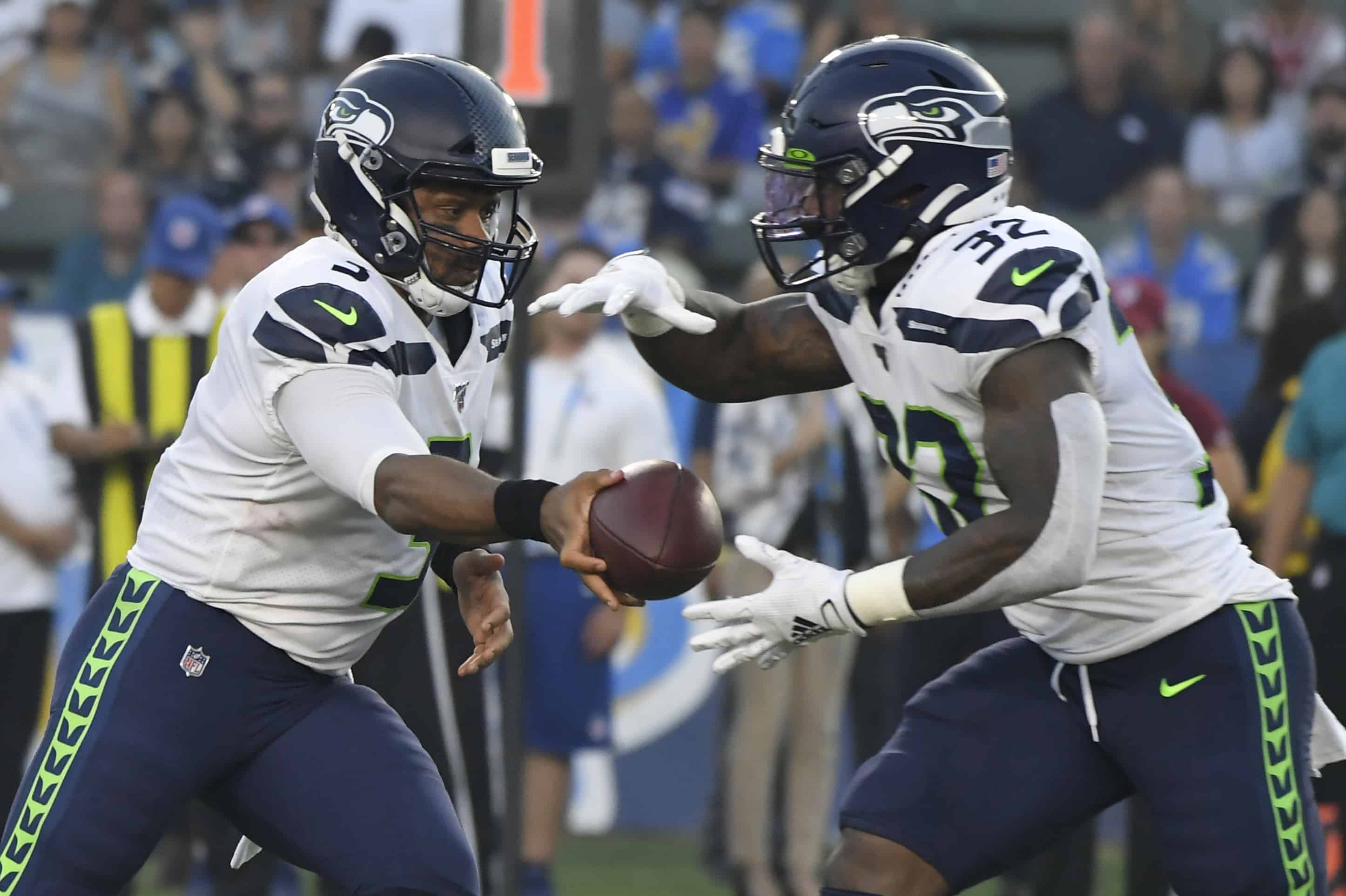 Seattle Seahawks QB Russell Wilson sadly hands the ball to Chris Carson