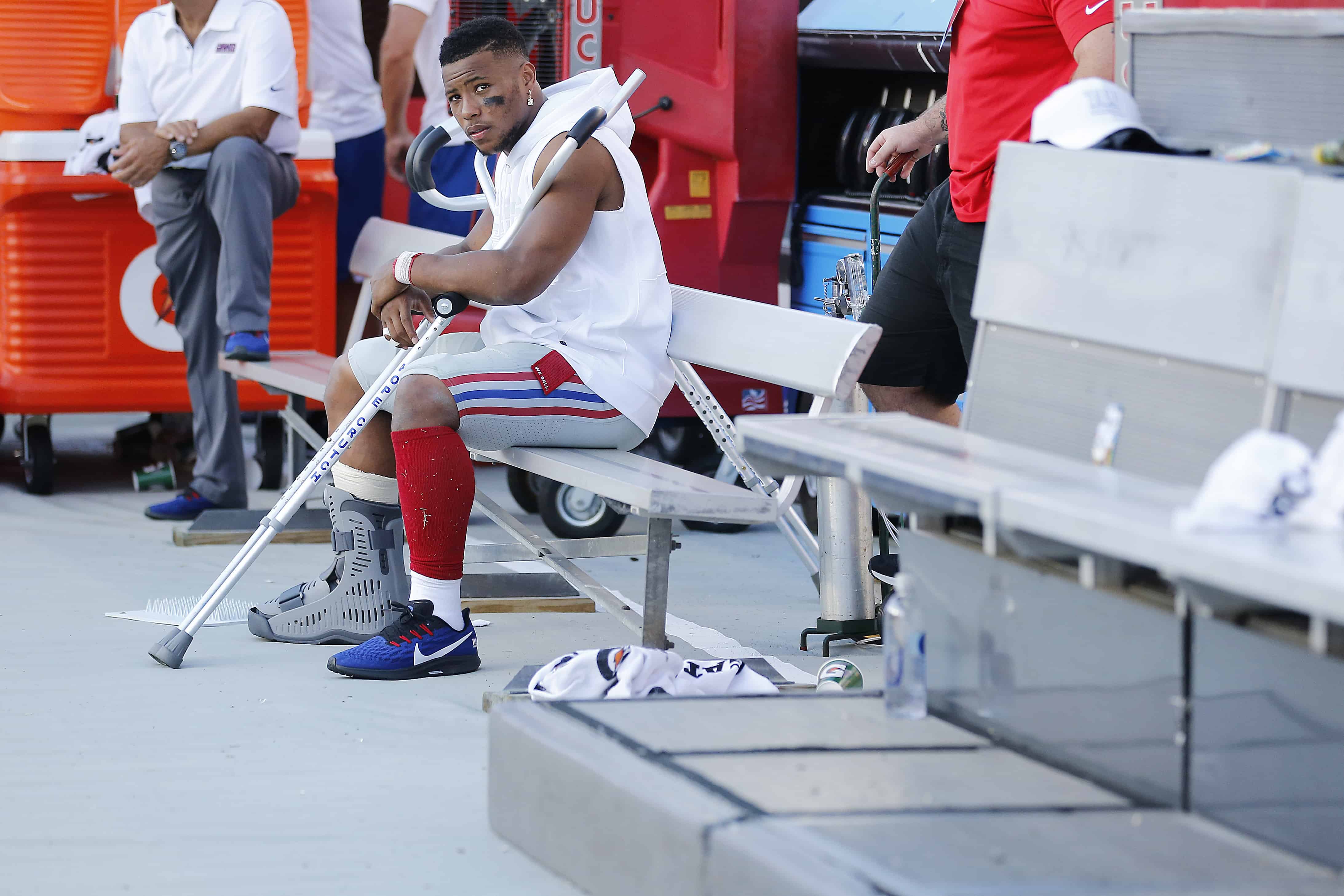 Saquon Barkley in a boot on the bench after injuring his ankle