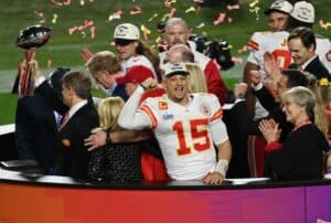 Patrick Mahomes #15 of the Kansas City Chiefs stands on the podium with owner Clark Hunt celebrating with the Lombardi Trophy