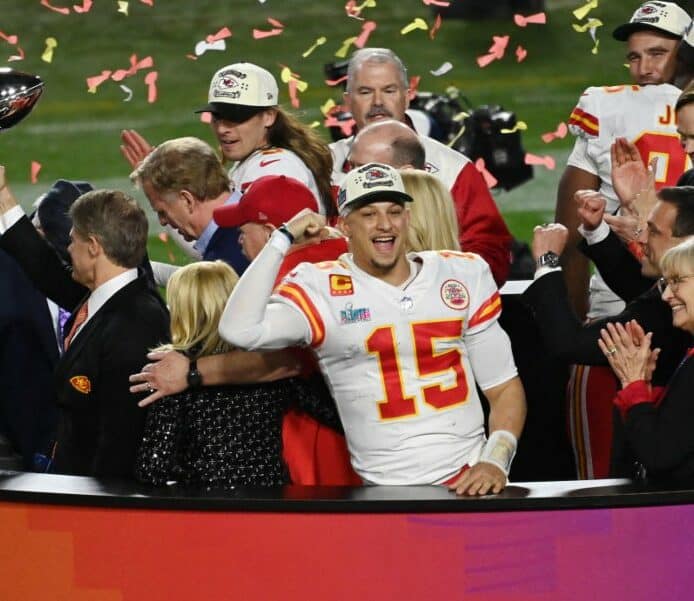 Patrick Mahomes #15 of the Kansas City Chiefs stands on the podium with owner Clark Hunt celebrating with the Lombardi Trophy