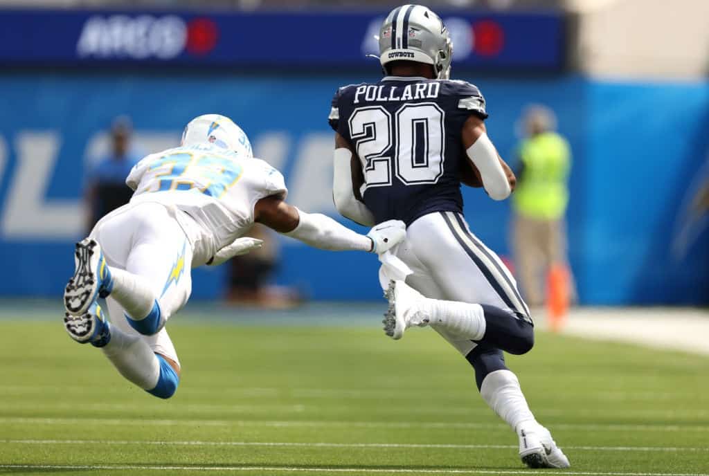 Tony Pollard #20 of the Dallas Cowboys runs from a tackle by free safety Derwin James