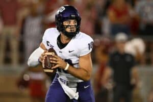 Quarterback holding football during college football game for Texas Christian University (TCU) at night.