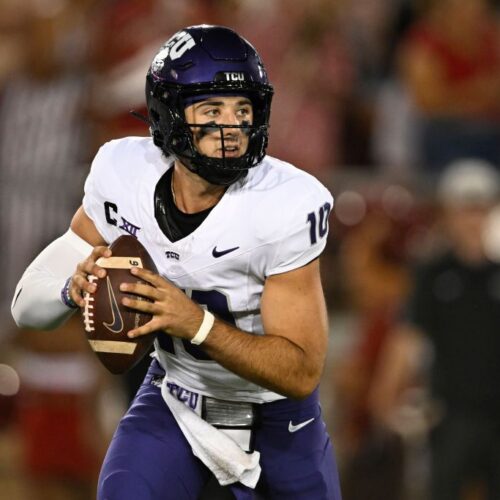 Quarterback holding football during college football game for Texas Christian University (TCU) at night.