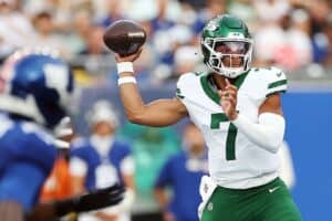 Quarterback throwing football during NFL game, in game action, NFL player in uniform, sports photography, football analysis.
