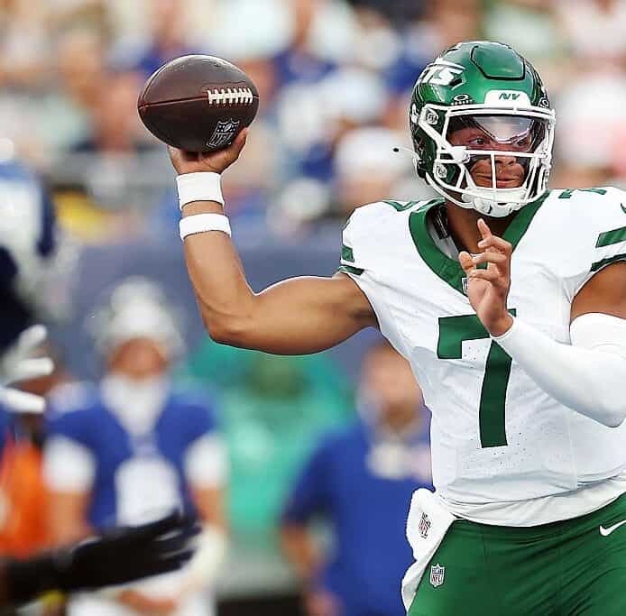 Quarterback throwing football during NFL game, in game action, NFL player in uniform, sports photography, football analysis.