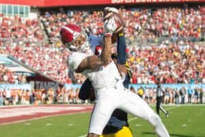 Stadium football game with player catching the ball during NFL match.