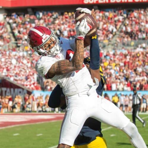 Stadium football game with player catching the ball during NFL match.