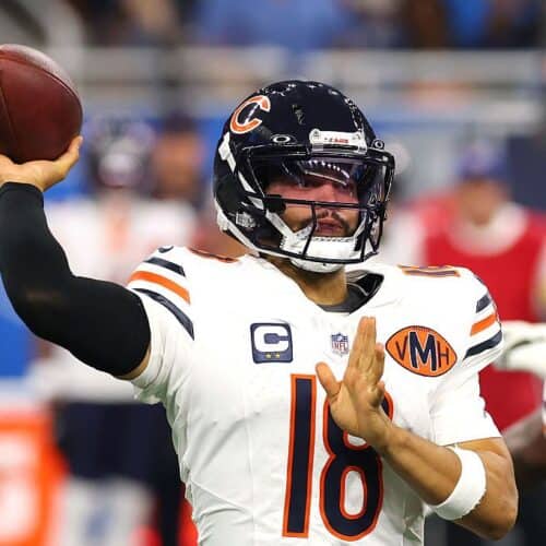 Quarterback throwing football during NFL game, Chicago Bears player in action.