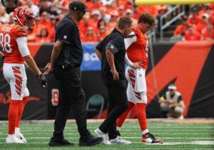 Injury consultation during an NFL game featuring Cincinnati Bengals players.
