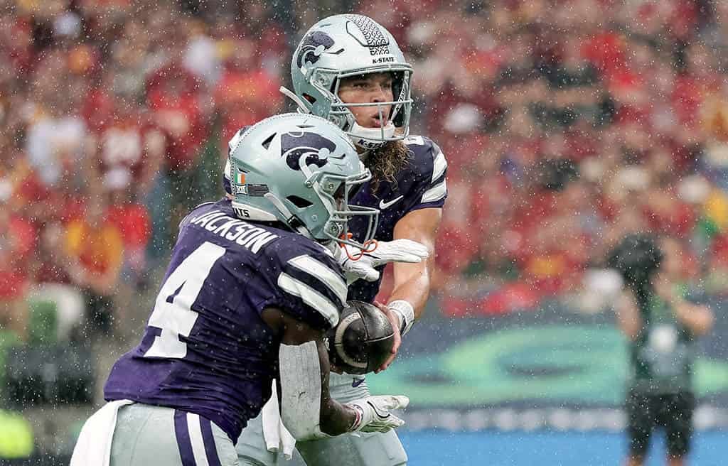 Kansas State quarterback Avery Johnson hands off the ball to his running back